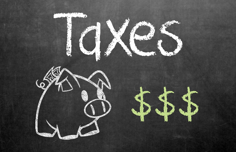 Taxes on chalkboard with little piggy and green $$$