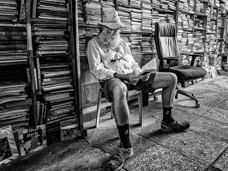 Photo of old guy reading in a bookshop